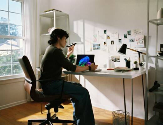 Person working at desk with laptop and phone; overplanning procrastination