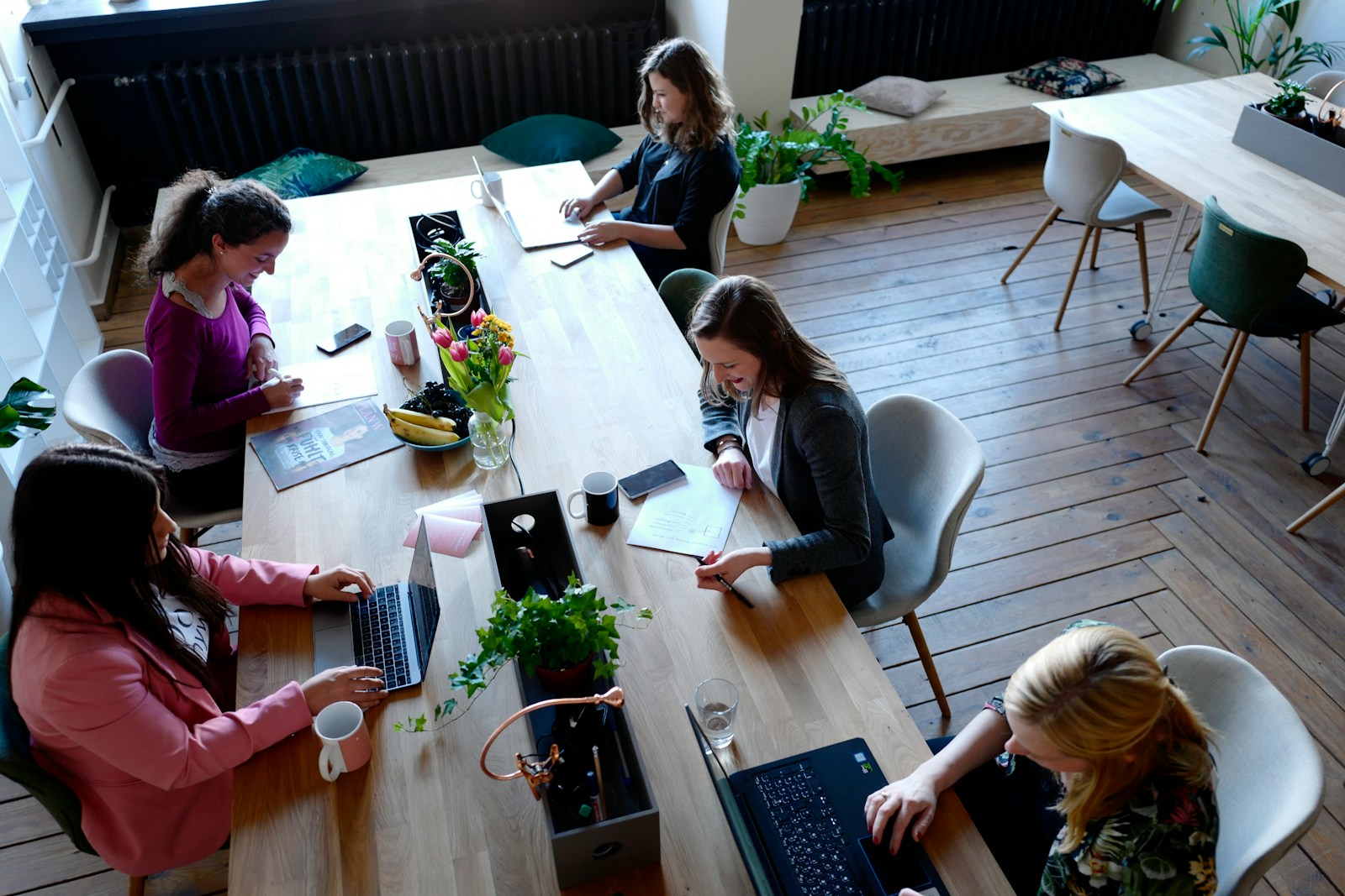 a group of people sitting around a wooden table; founders break rules